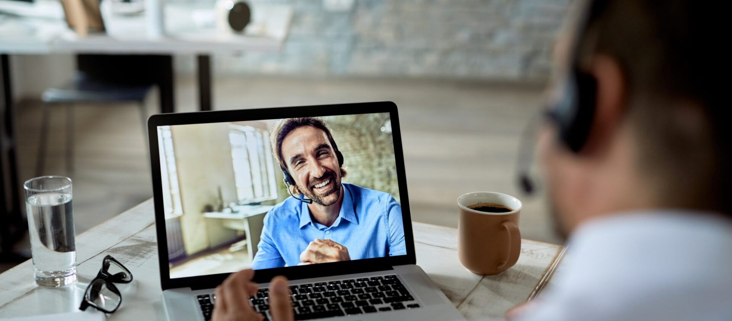 Close-up of businessman talking to his happy colleague over a la