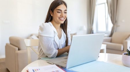 Focused businesswoman presenting charts and graphs on video call online. Young business woman having conference call with client on laptop. Closeup business woman working laptop computer indoor.