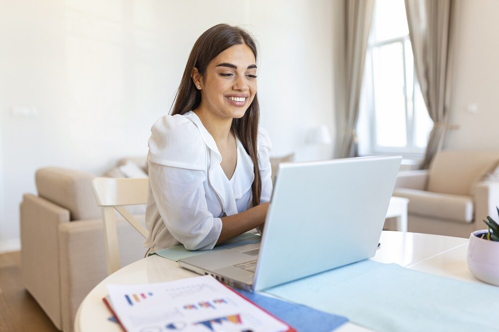 Focused businesswoman presenting charts and graphs on video call online. Young business woman having conference call with client on laptop. Closeup business woman working laptop computer indoor.