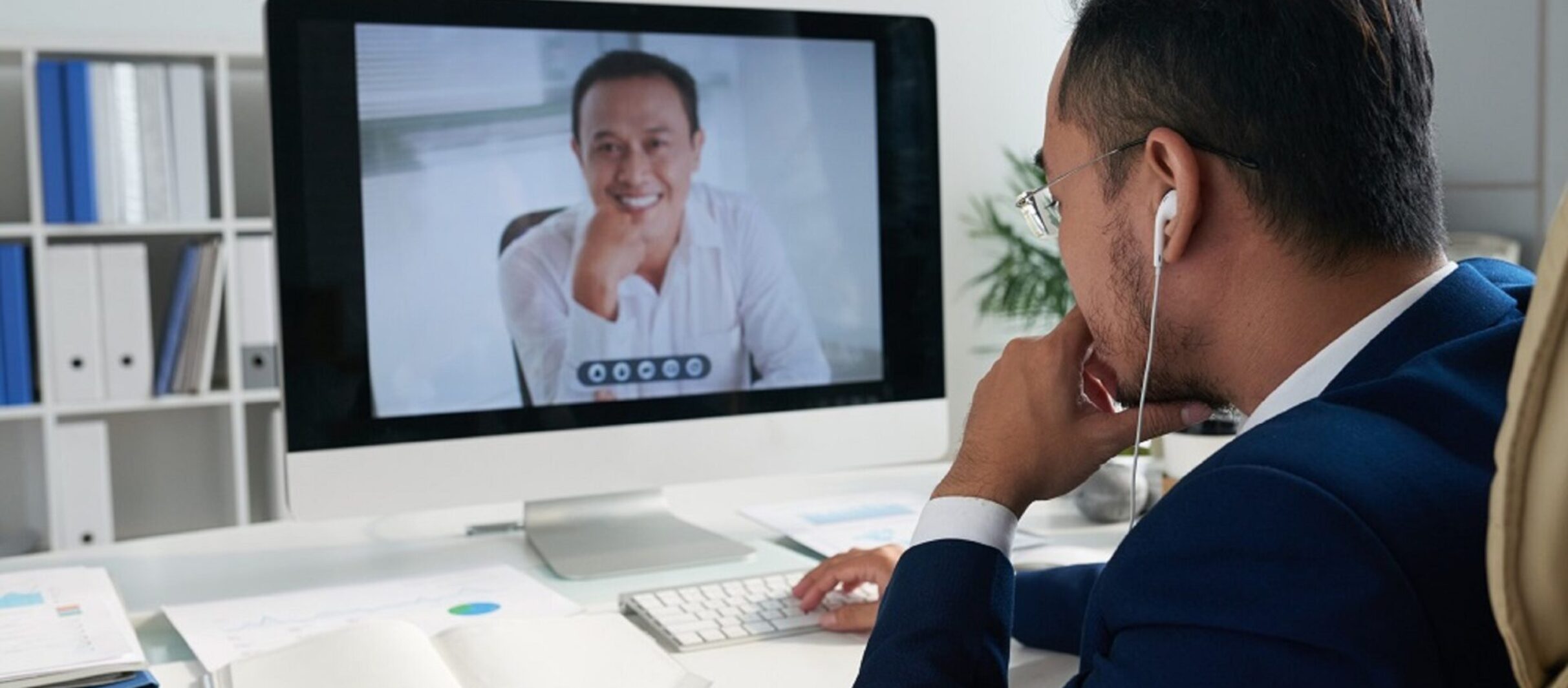 Entrepreneur sitting at his table and videocalling to business partner